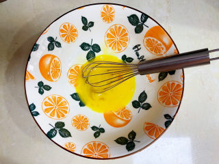 胡萝卜鸡蛋饼,接着再碗里打入一个鸡蛋打散。