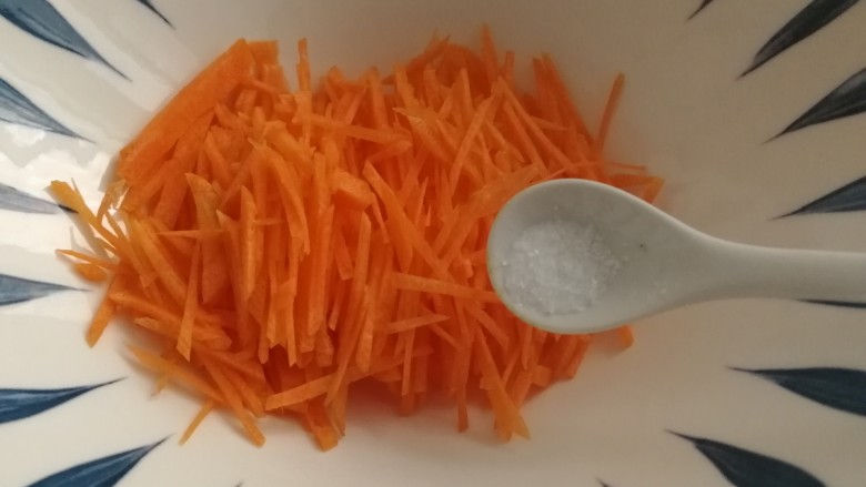 胡萝卜鸡蛋饼,胡萝卜丝放入大碗里，加一点点盐。