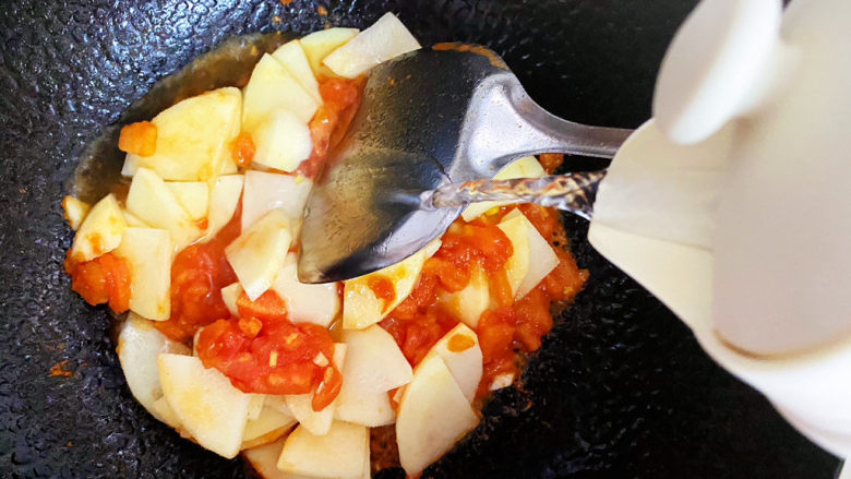 西红柿炒土豆片,接着倒入水。