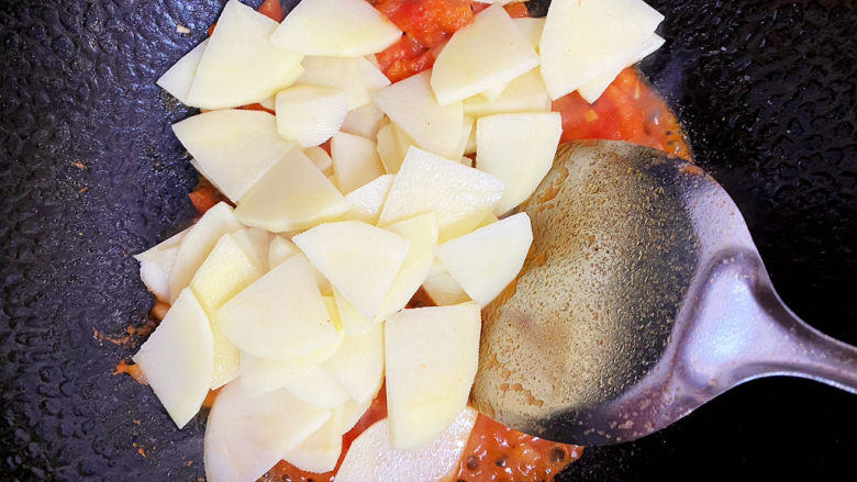 西红柿炒土豆片,待西红柿炒出汤汁，倒入土豆片继续翻炒。