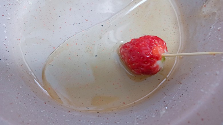 草莓糖葫芦,关火，草莓迅速在糖浆里裹一圈然后方在油纸上等待凝固