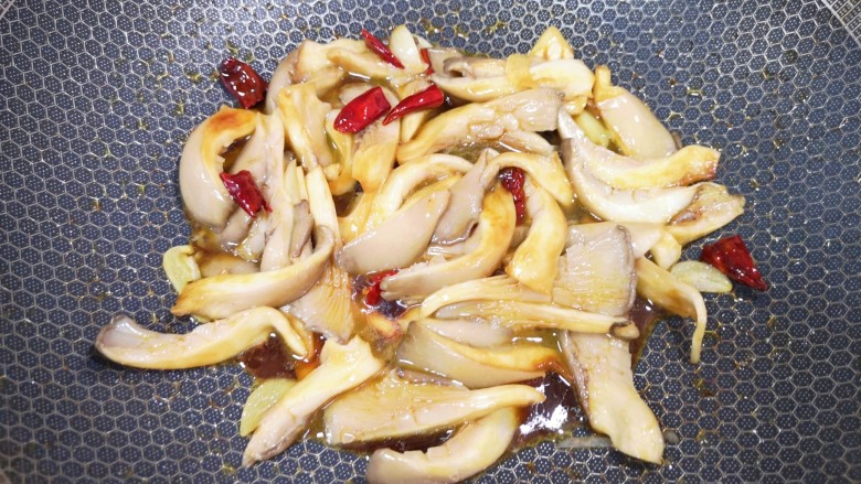 青椒炒平菇,加入1勺红烧酱油翻炒至平菇变软。