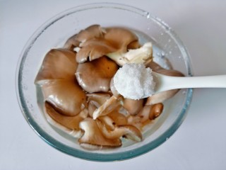 青椒炒平菇,加一勺食用盐浸泡一下，再用清水冲洗干净。