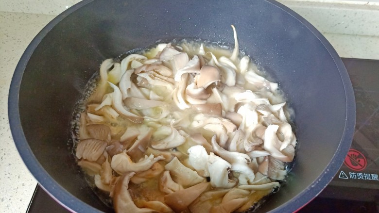 青椒炒平菇,热锅凉油放入蒜泥爆香，再放入平菇翻炒。