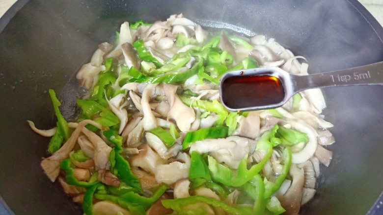 青椒炒平菇,加入生抽一勺蚝油一勺。