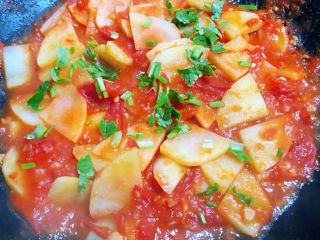 西红柿炒土豆片,最后撒上香菜提鲜即可出锅享用