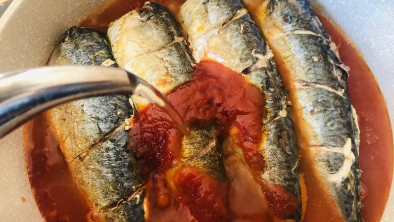 茄汁鲅鱼,倒入适量热水，水量没过鲅鱼半个鱼身即可。盖上盖子先用大火烧开。