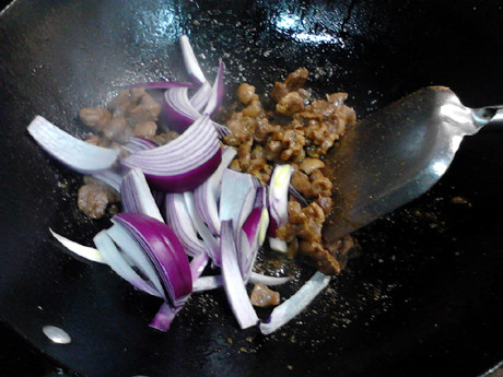 羊肉抓饭,放入洋葱继续翻炒至洋葱变软。