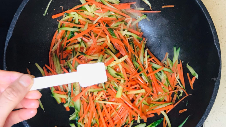 黄瓜炒胡萝卜,一直翻炒至蔬菜断生恹恹后，撒入盐调味