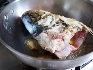 鱼头豆腐煲,油热后，转小火，慢慢煎制鱼头至两面微焦定型。