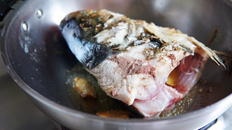 鱼头豆腐煲,油热后，转小火，慢慢煎制鱼头至两面微焦定型。