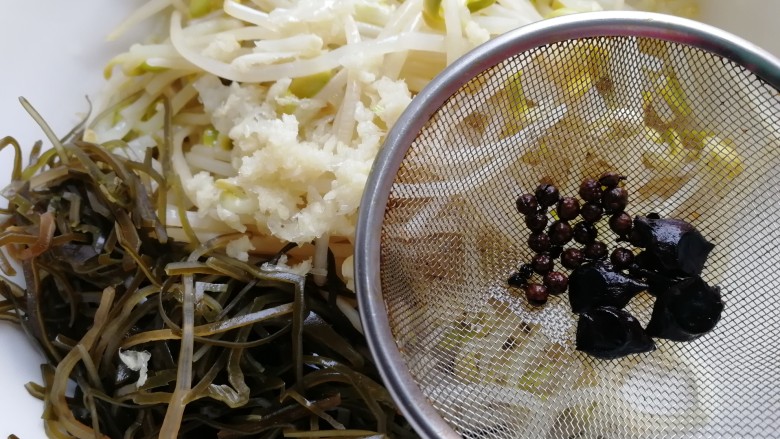 黄豆芽拌海带,热油浇到蒜泥上，纱网滤去花椒，八角。