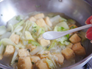 油豆腐炒白菜,加入味精提鲜调味。