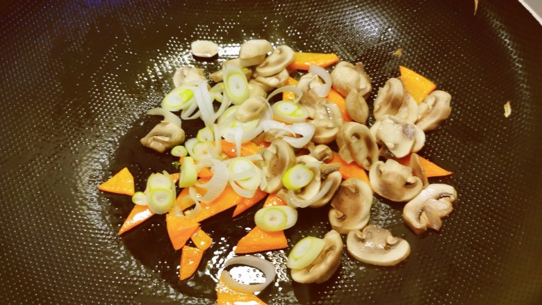 油豆腐炒白菜,放入口蘑和葱片，翻炒均匀。