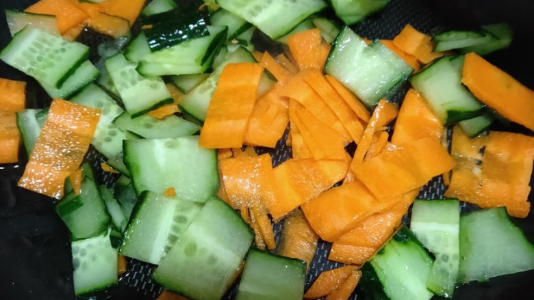 黄瓜炒胡萝卜,锅中倒入适量油烧热，再将黄瓜胡萝卜片儿倒入锅里炒