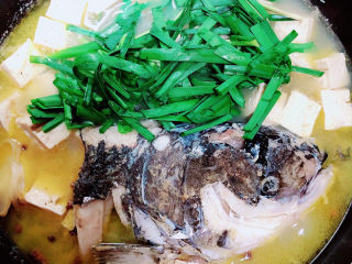 鱼头豆腐煲,撒上韭菜段入味。