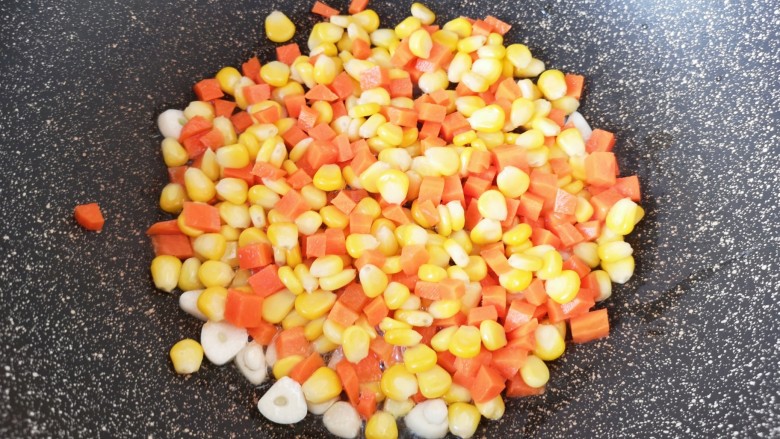 胡萝卜炒玉米,下入胡萝卜丁和玉米粒。