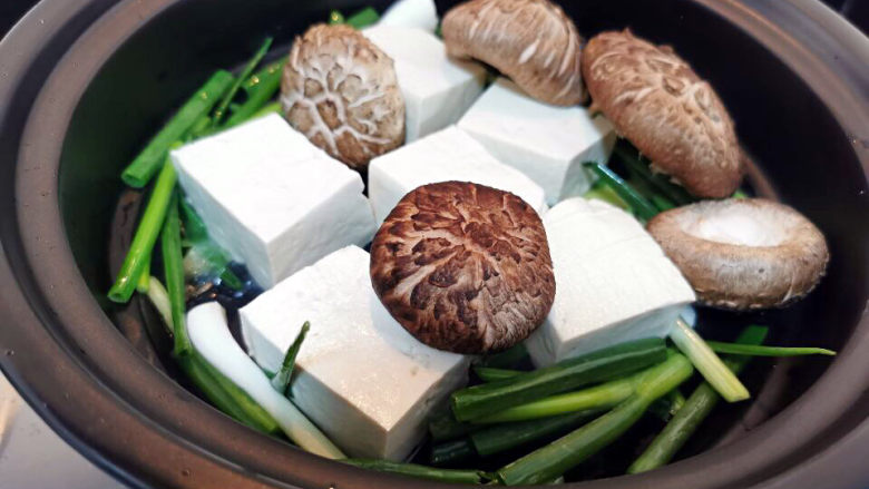 鱼头豆腐煲,下豆腐及香菇煎香