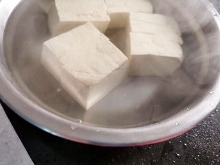 鱼头豆腐煲,豆腐切块，用热水冲泡