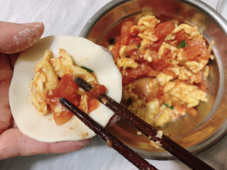 西红柿鸡蛋饺子,然后取一片饺子皮，夹适量馅料与饺子皮中心
