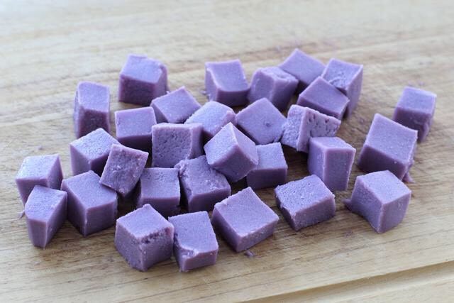 紫薯布丁,待紫薯布丁完全凝固定型后取出，用小刀沿着玻璃碗壁划一圈，倒扣出紫薯布丁，撕掉油纸后切成小块食用即可。