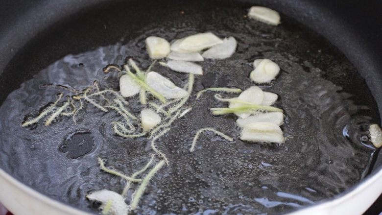 尖椒肉丝,锅中倒适量食用油烧至五成热，放入姜丝和蒜片小火炒香。