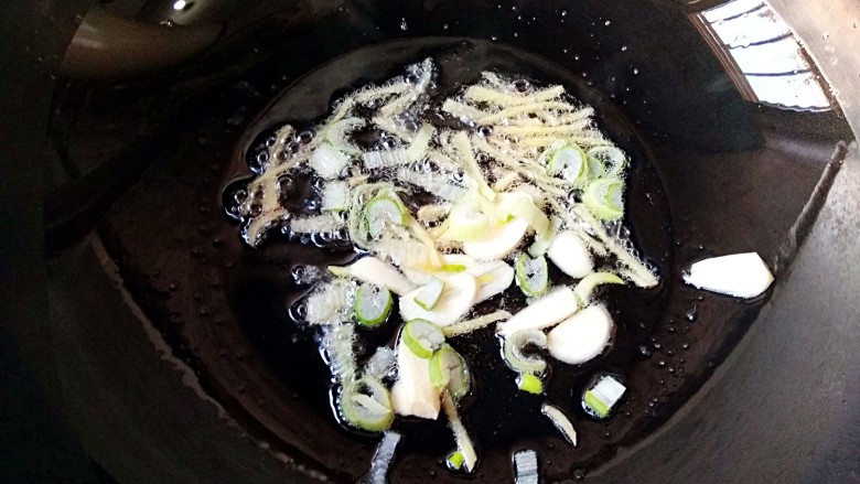 尖椒肉丝,锅中适量油烧至7成热，放入葱花，蒜瓣和姜丝爆出香味儿。