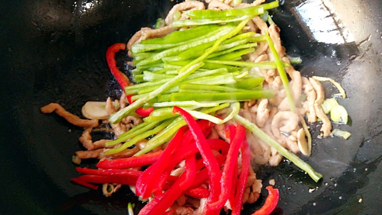 尖椒肉丝,炒至肉丝变色后加入青红椒丝，翻炒断生。