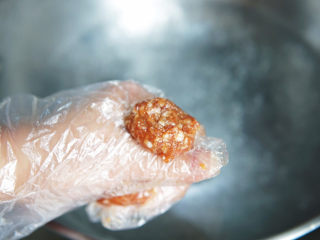 肉丸粉丝汤,起一锅沸水，戴上一次性手套，手拿一些肉馅，用虎口部位挤出一个个肉圆，时常用汤勺搅拌一下，让肉丸子均匀受热。