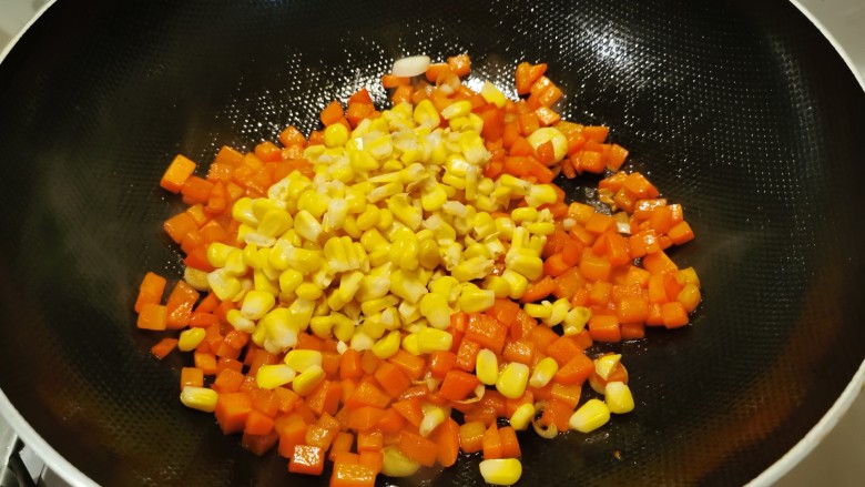 胡萝卜炒玉米,放入玉米粒翻炒。