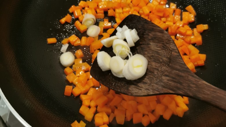 胡萝卜炒玉米,翻炒断生后放入葱片。