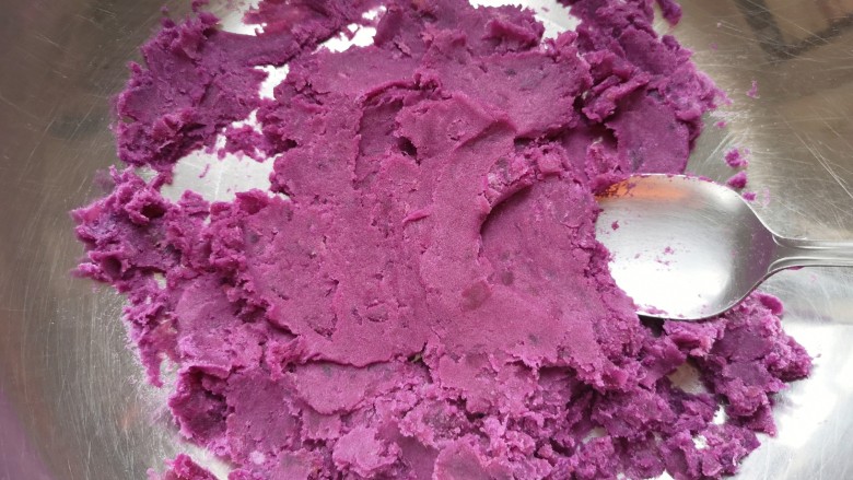 紫薯发糕,蒸熟的紫薯放入盆里，用勺子压成紫薯泥。
