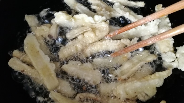 椒盐杏鲍菇,中小火慢炸，筷子翻动让其受热均匀。