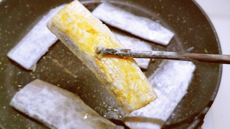 茄汁带鱼,起油锅，放入食用油，将裹好面粉的带鱼码放锅中，煎至一面金黄色，翻另一面。