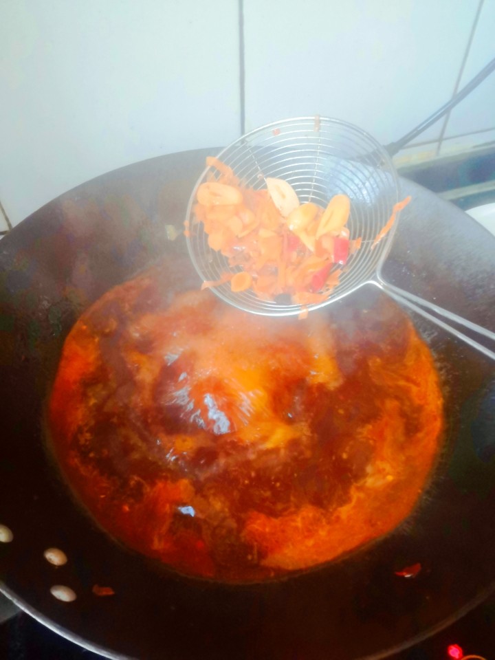 超好吃的川菜⇒水煮肉片（做法超级简单呦）,把青菜捞出放在盘子中，用漏勺捞出料渣扔掉