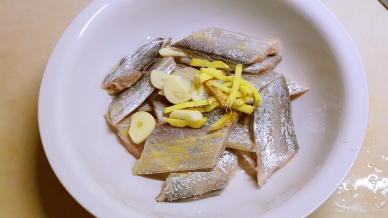 清蒸带鱼,带鱼收拾干净切成段，放入蒜片和姜丝。