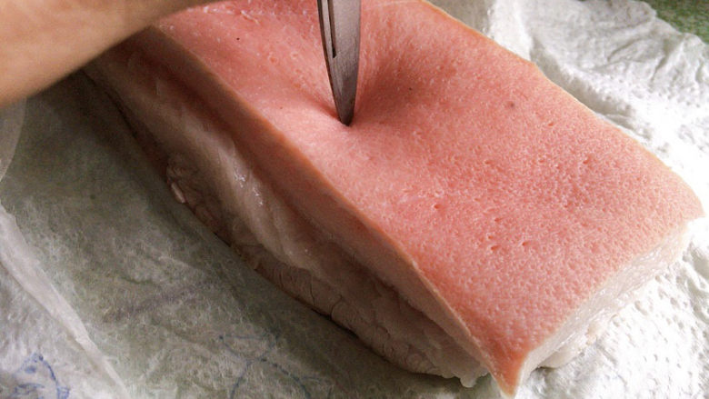 芋头扣肉,用小刀尖，在猪皮表面扎孔，防止再过油的时候，皮脂膨化油飞溅烫伤。
