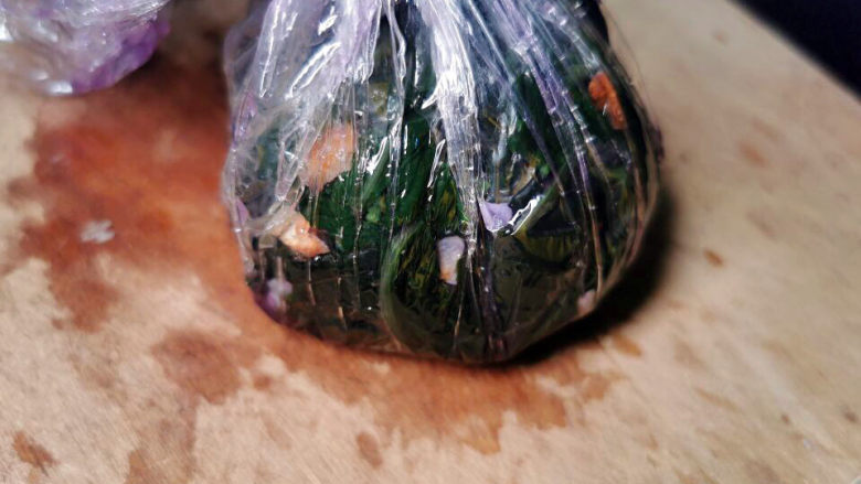 酥心糖拌紫背天葵,拌好的紫贝天葵用保鲜膜包紧，成包子状