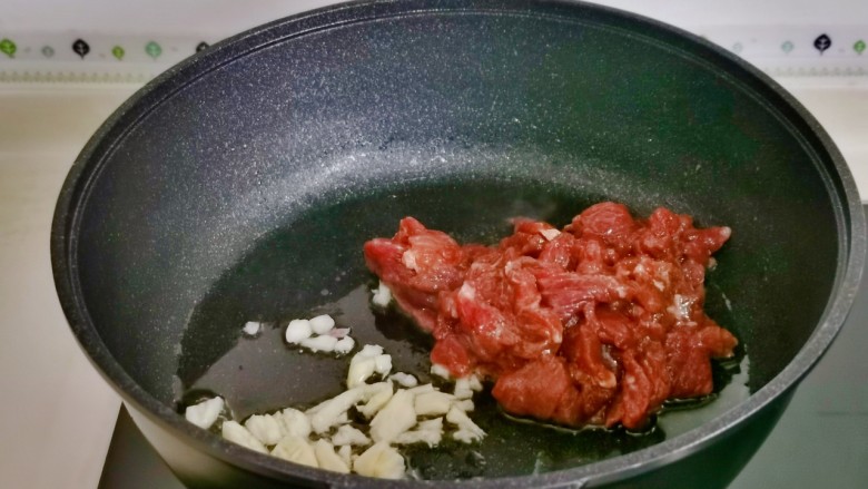 洋葱炒肉片,起油锅，加入蒜末煸炒，再加入腌制好的牛肉。