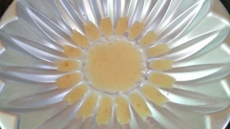 太阳花千层糕,模具表面扫一层油防粘，在花心部分和花瓣的位置加入少量红糖粉浆