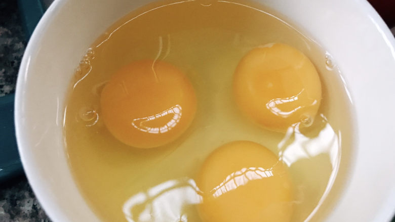 番茄炒蛋,磕三个鸡蛋进碗中