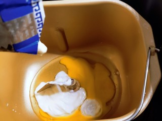 酸奶面包,酸奶和其中一个鸡蛋放入面包机内胆里面。