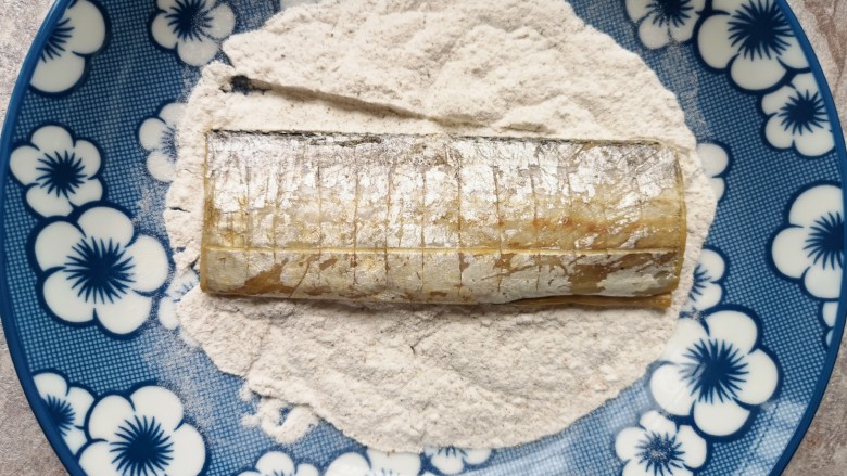 干煎带鱼,将腌好的带鱼段放在淀粉里面，两面粘上干粉。