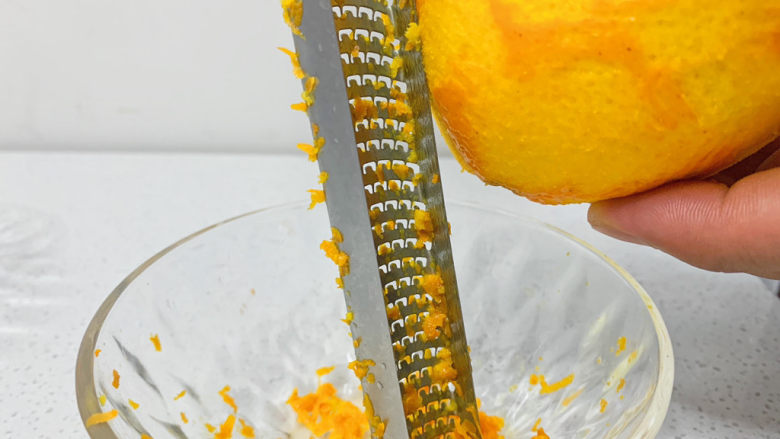 橙子蛋糕,橙子的处理：1⃣️用淀粉盐水洗净橙子表皮。2⃣️刮取橙子皮，小心不要刮到白色皮肉部分，否则会有苦涩味。