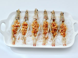 鲜掉眉毛的开背基围虾,把做好的蒜蓉调料汁，均匀地浇到虾背里。