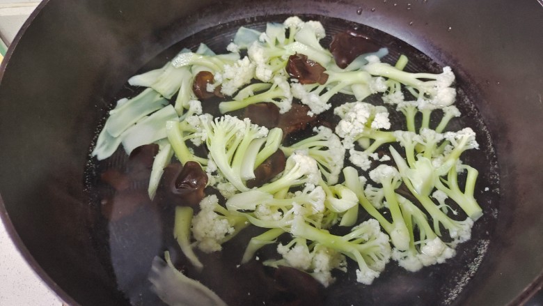 花菜炒鸡蛋,锅中加入适量清水煮开，放入花菜和木耳焯水捞出备用