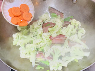 腊肉炒花菜,放入胡萝卜。