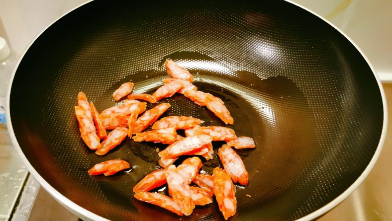 黄瓜炒腊肠,起油锅放入食用油，油热后放入腊肠翻炒。