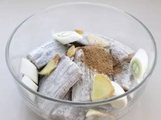 干煎带鱼,将切好的葱段和姜片放进去，再加入料酒、五香粉和盐。