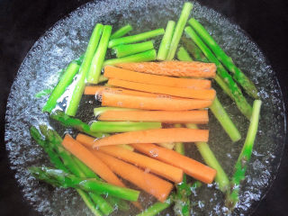 培根芦笋卷,后放入胡萝卜烫一下，蔬菜捞出待用。